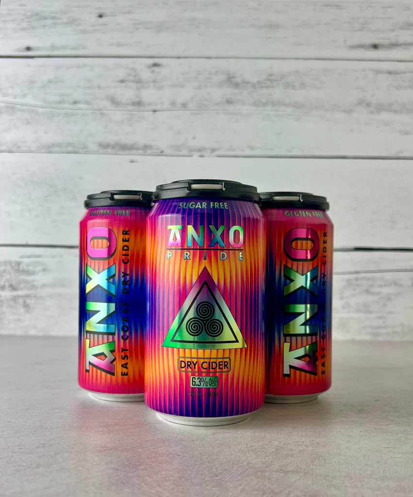 photo of a 4-pack of 12-oz cans of Anxo Pride dry cider with a colorful design on a white wooden background