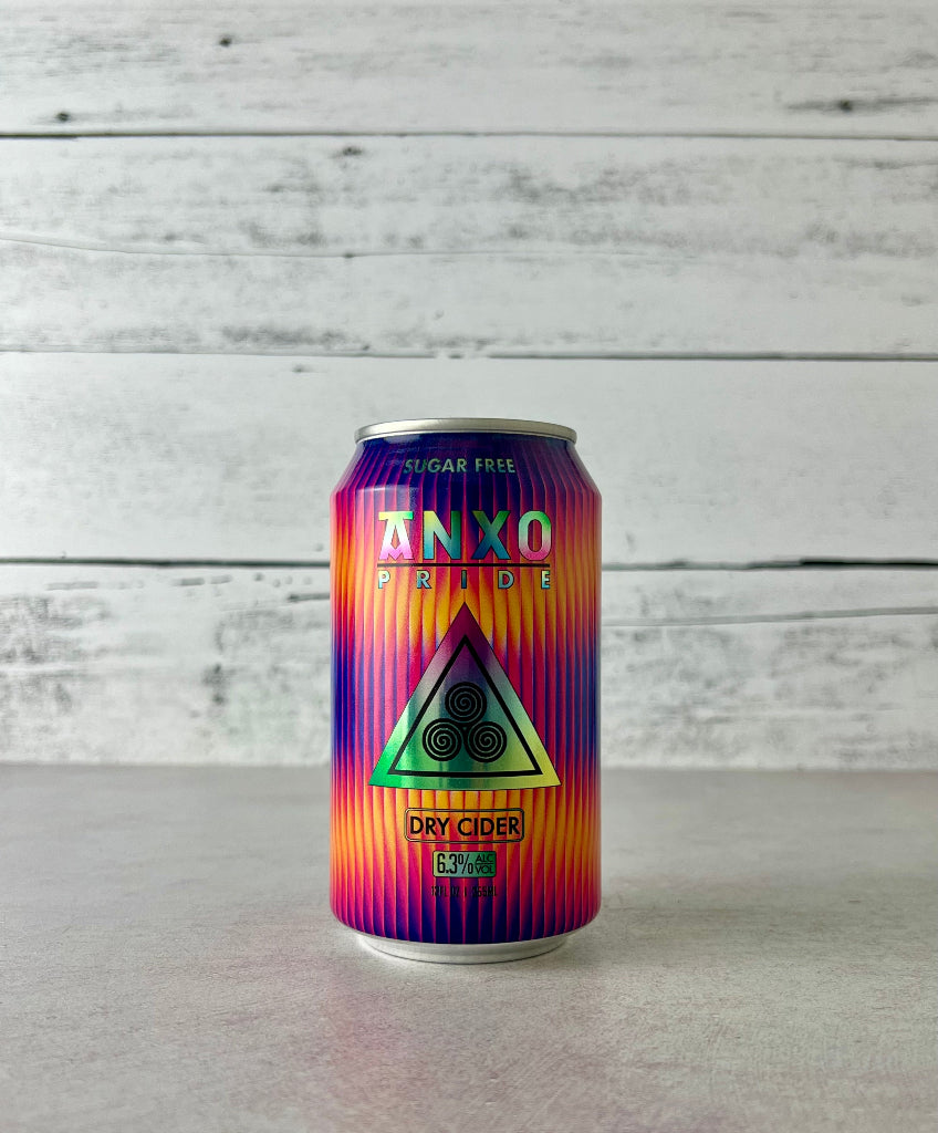 photo of a 12-oz can of Anxo Pride dry cider with a colorful design on a white wooden background