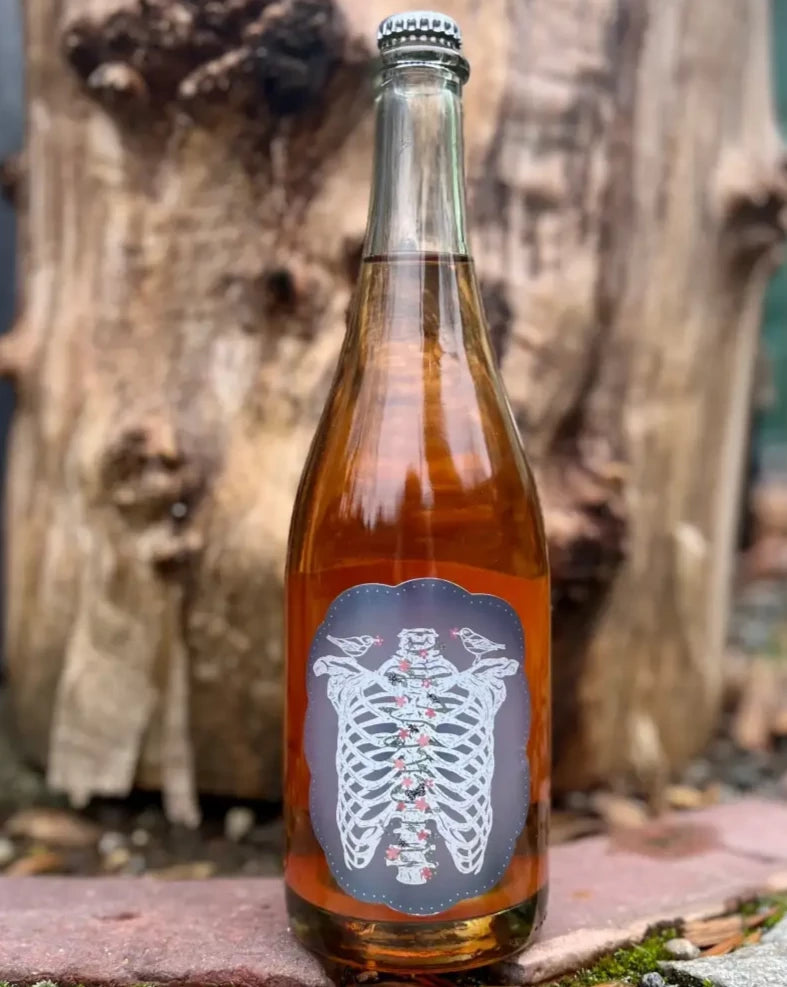 Art + Science Cider - Fruit Nat Coferment (750 mL) - Cider - Art+Science Cider Hard Cider in front of a log