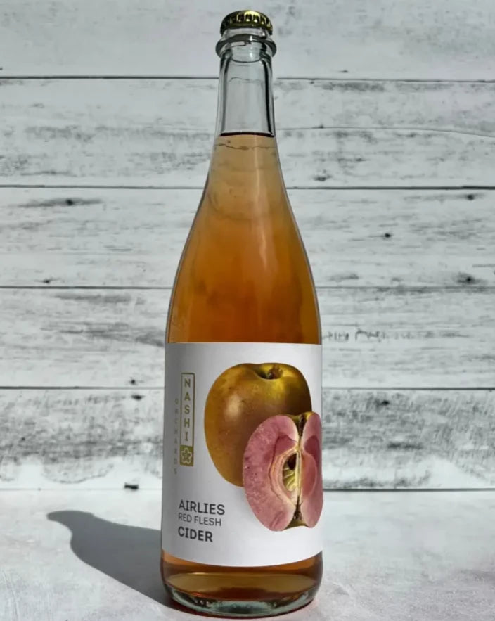 750 mL clear glass bottle of pink-hued Nashi Orchards Airlies Red Flesh Cider